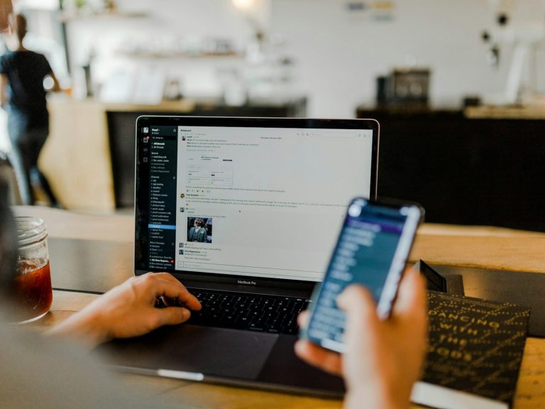 Individuelle Marketing-Strategie planen Arbeitsplatz mit Laptop und Smartphone zur Planung einer digitalen Marketing-Strategie.